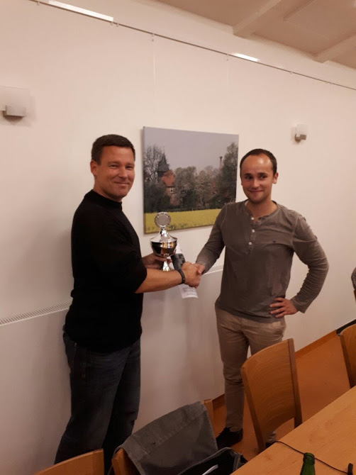 Der 1.Vorsitzende Nando Seitz (links) überreicht dem Pokalsieger Timo Heitmann (rechts) den Wanderpokal sowie den Chessbase-Gutschein