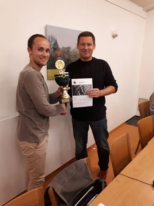 Der 2.Vorsitzende Timo Heitmann (links) überreicht dem Vereinsmeister Nando Seitz (rechts) Pokal und Chessbase Gutschein